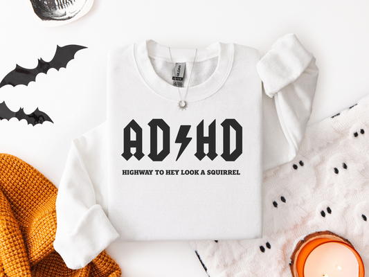 White unisex Gildan sweatshirt with black bold "ADHD Highway to Hey Look a Squirrel" design and lightning bolt graphic, cozy fall style